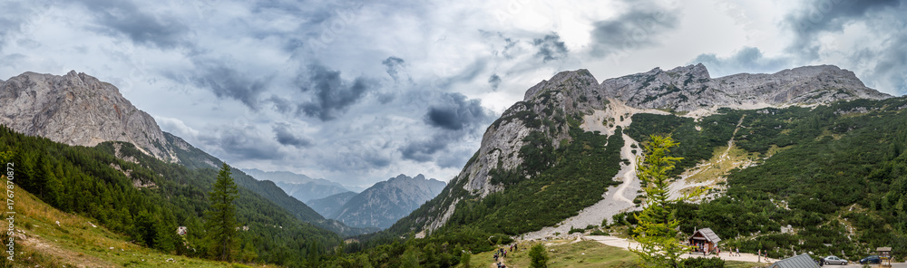 Obraz premium Explore the stunning landscape of Vrsic Pass in Bovec, Slovenia showcasing majestic mountains and a dramatic sky. Perfect for nature lovers.