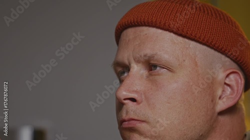 Close-up of a man sitting in a minimalist kitchen. The shot conveys home comfort, simplicity, and calmness of everyday domestic life. High quality 4k footage