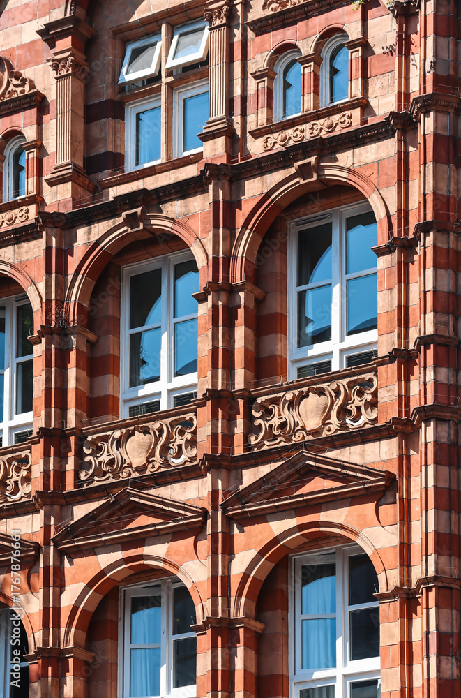 Fototapeta premium London, United Kingdom - August 13, 2022: Ornate Victorian red and beige brick building facade in the Kensington district