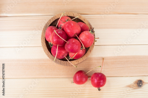 Apples. The fruits of a small-fruited apple tree in a wooden bowl on a light wooden background.