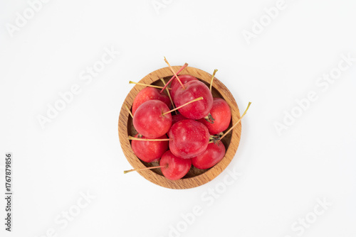 Apples. The fruits of a small-fruited apple tree in a wooden bowl on a white background.
