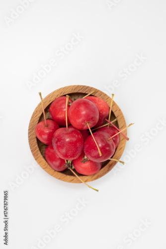 Apples. The fruits of a small-fruited apple tree in a wooden bowl on a white background.
