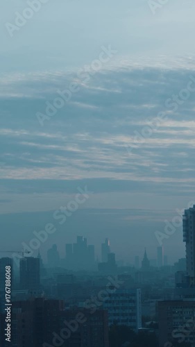 Vertical frame of a dense city skyline right after sunset. Cool light tones and urban texture create a feeling of calm evening serenity. High quality 4k footage