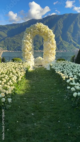 footage of a luxury wedding floral arch set for a destination ceremony overlooking Lake Como and alpine mountains at an elegant Italian villa, romantic destination wedding