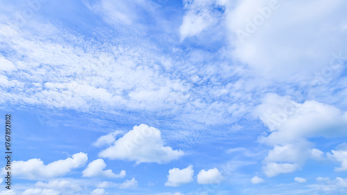 A wide, bright blue sky flled with a mix of fluffy cumulus and wispy cirrus clouds, providing a serene nd atmospheric background.