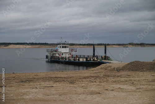 quiet ferry at shoreline, tranquil rural scene featuring boat anchored at misty river edge