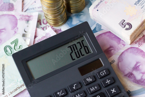 Turkish Money Banknotes on the white surface with coins and black calculator with 2026 numbers on	