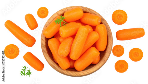 Top-down of baby carrots in a wooden bowl, with carrot slices and sprigs of parsley on a stark black backdrop