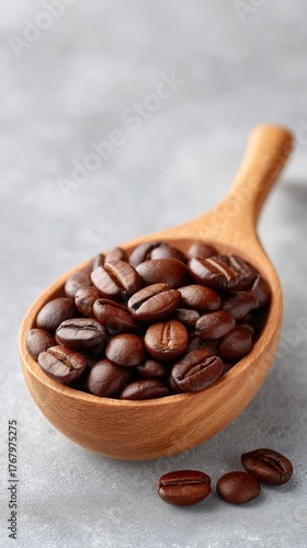 Close up Rustic Wooden Spoon Filled With Rich Dark Roasted Coffee Beans On A Textured Grey Background With A Shallow Depth Of Field