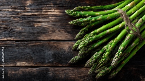 Fresh green asparagus bunch on rustic wooden background.