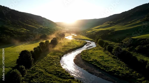Aerial view of a winding river flowing through a lush green valley at sunrise outdoor, trees, discovery