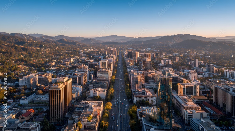Fototapeta premium High angle aerial view captures urban development stretching towards distant rolling terrain during sunrise
