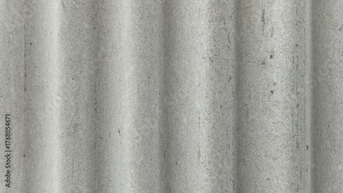Gray corrugated fiber cement sheet texture background with vertical waves and weathered, rough surface.