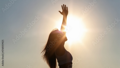 Strong confident woman! Winning and life goals concept. Silhouette of a woman reaching towards the sun against a bright sky.