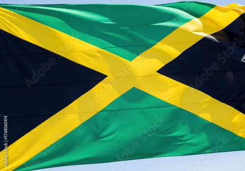 Vibrant national flag of jamaica fluttering proudly in the wind against the sky