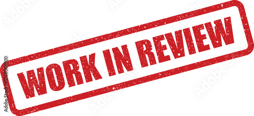 A red distressed rectangular rubber stamp mark displaying the phrase WORK IN REVIEW for process status