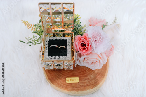 Fototapeta Naklejka Na Ścianę i Meble -  Luxury Wedding Rings in Crystal Box with Pink Roses on Wooden Base