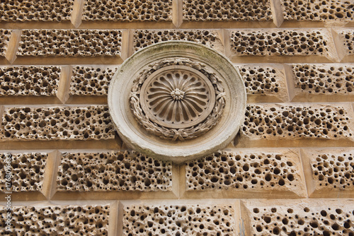 Brick wall hole with circular art sculpture as background.