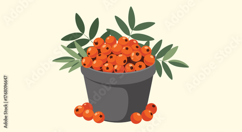 Bowl full of bright orange rowan berries with green leaves and scattered berries on a light background.