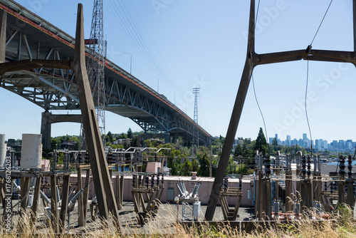 Low angle view of freeway bridge, specifically the the Ship Canal Bridge/I-5, as seen from behind transformer station. Taken while walking in the Seattle urban area on a clear July day.