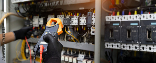 Electrical technician hand checking electricity circuit breaker main power on switchboard cabinet for service maintenance and electric cable wiring check for safety concepts.