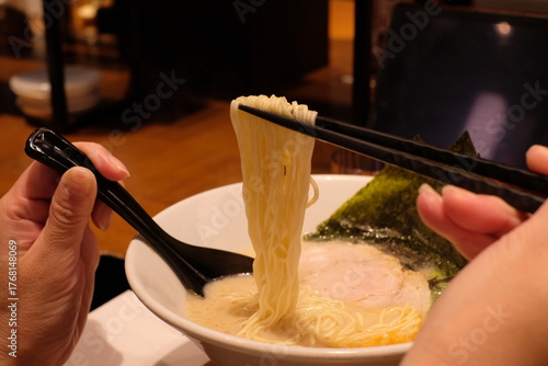 woman eating the Japanese ramen noodles in the bowl
