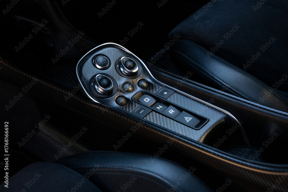 Obraz premium Interior close up of luxury British sport car carbon fiber center console with transmission buttons and start stop control. High performance design featuring premium materials and modern ergonomics