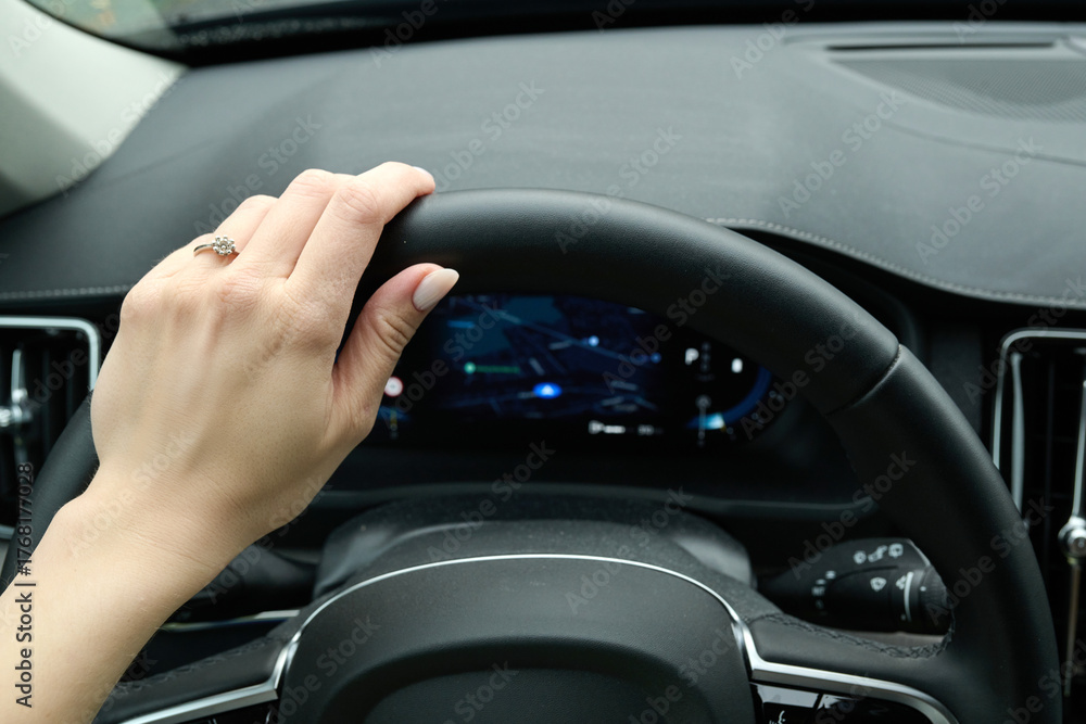 Obraz premium Driver hand holding steering wheel inside modern connected car