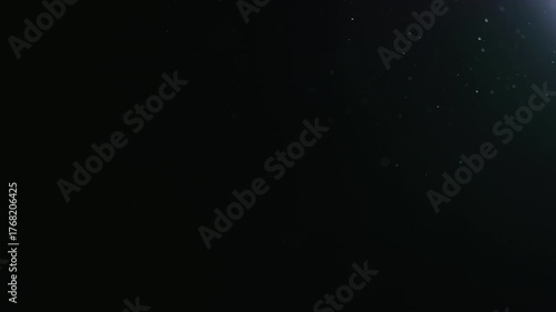 Slow motion natural dust particles float in air on black background