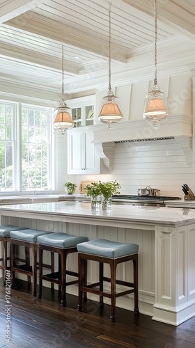 Bright, Luxurious White Kitchen Island with Teal Bar Stools, Marble Countertop, Elegant Pendant Lights, and Large Window View