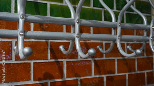 Metal coat rack hooks on colorful brick wall background