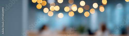 Office holiday party with festive lights creating warm bokeh effect and blurred coworkers in modern workspace atmosphere