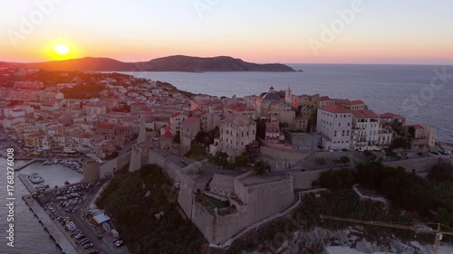 Aerial view of morning coastal fortress Calvi, golden sunrise citadel and surrounding landscape. Corsica. France
