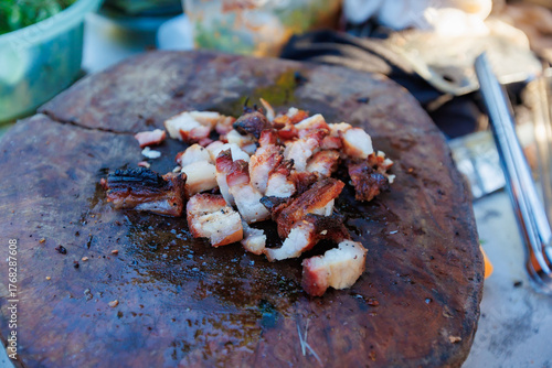 A man grills pork in a crispy, fragrant pot at a party. The crispy pork chops are a popular dish in Thailand.