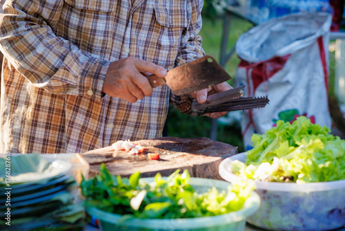 A man grills pork in a crispy, fragrant pot at a party. The crispy pork chops are a popular dish in Thailand.