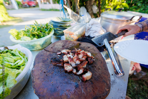 A man grills pork in a crispy, fragrant pot at a party. The crispy pork chops are a popular dish in Thailand.