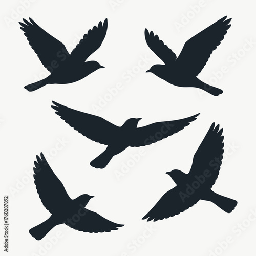 Set of flying birds silhouettes on beige background. Vector illustration.