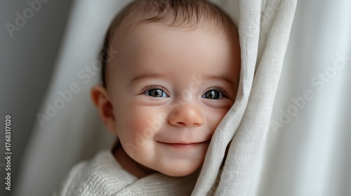 Adorable bébé aux yeux bleus souriant enveloppé dans une couverture