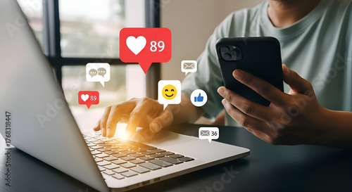 Person using laptop and smartphone with social media icons and notifications overlayStock photo for website - Business and technology concept photo