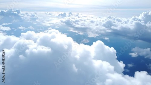 Vast expanse of fluffy white clouds in the sky above the ocean with a hint of land visible