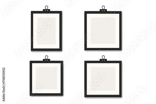 Four blank black picture frames held by binder clips on a white wall mockup