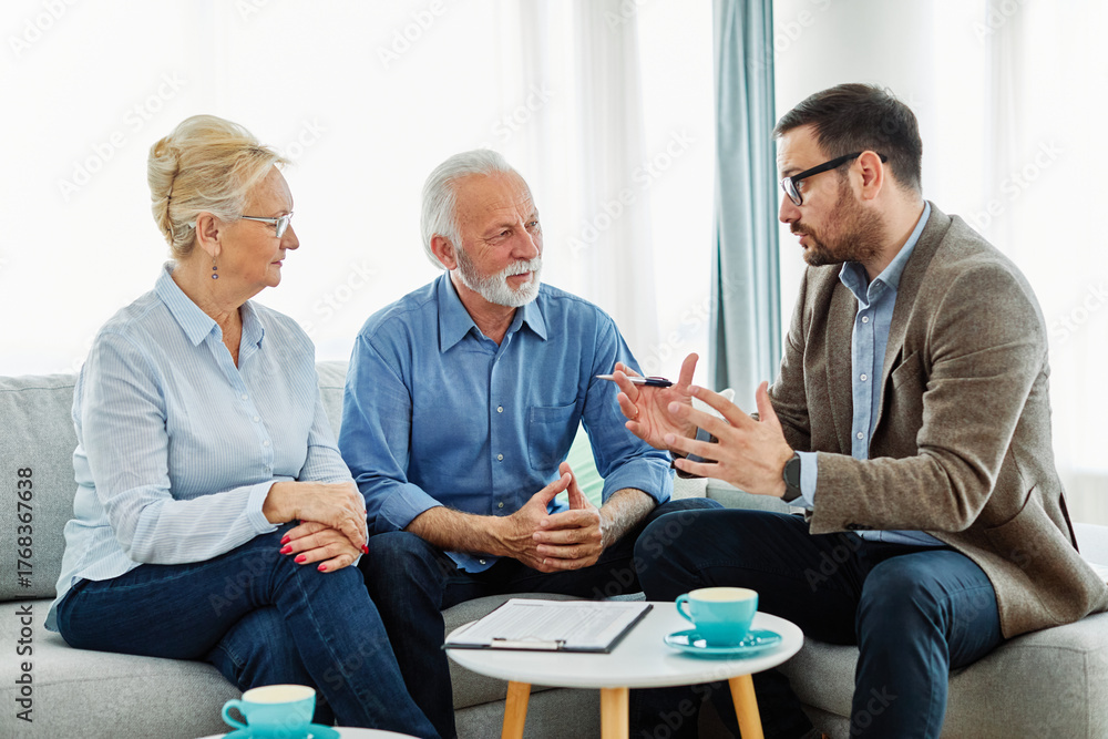 Obraz premium Portrait of a businessman or real estate agent or doctor shaking hands and signing a deal contract with senior couple in his office