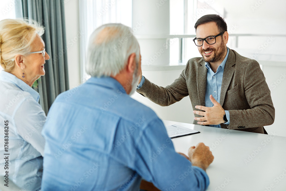 Obraz premium Senior couple having a meeting with an agent, businessman, salesperson or doctor in his office