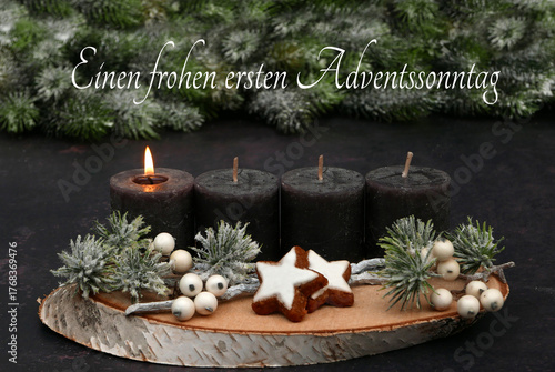  Arrangement für den ersten Advent : Dekoration mit vier braunen Adventskerzen, Tannenzweigen und Zimtsternen auf einer Holzscheibe dekoriert.