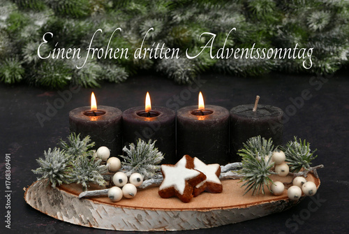  Arrangement für den dritten Advent : Dekoration mit vier braunen Adventskerzen, annenzweigen und Zimtsternen auf einer Holzscheibe dekoriert.