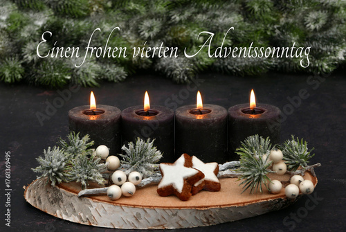  Arrangement für den vierten Advent : Dekoration mit vier braunen Adventskerzen, Tannenzweigen und Zimtsternen auf einer Holzscheibe dekoriert.