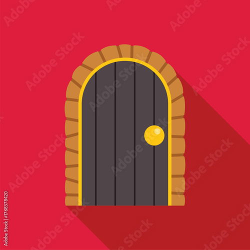 Closed arched wooden door with golden doorknob on a red wall casting a long shadow