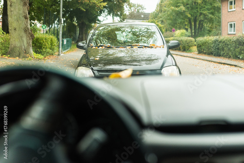 view of a car showing the steering wheel, dashboard, and front panel in focus. Soft natural light highlights the modern design and textures of the vehicle interior, creating a realistic driv