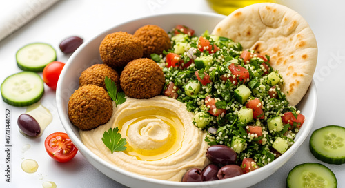 Enjoy delicious falafel bowl with hummus, salad, and pita bread for a healthy Mediterranean meal