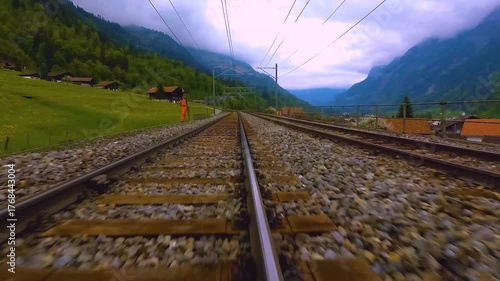 A time lapse low angle view of train tracks riding across the kandertal valley in switzerland on a cloudy day